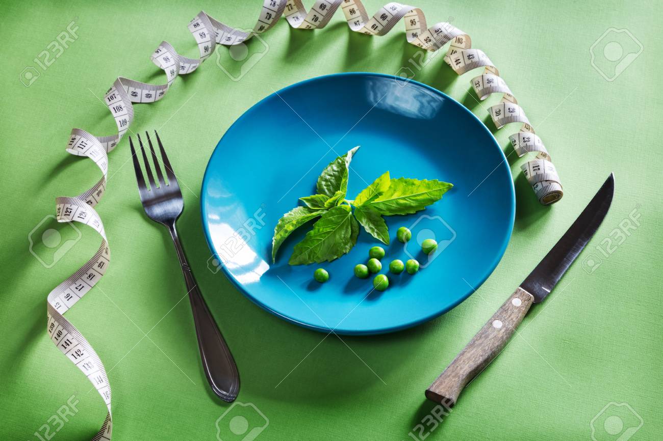 Diet blue plate with centimeter, basil and peas