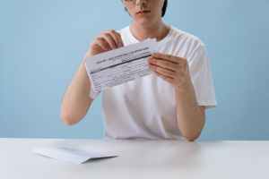 man in white t shirt holding hiv aids paper form