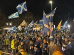 A pro-independence rally in front of the Scottish parliament. The image features a crowd, many of whom are flying the Scottish saltire.