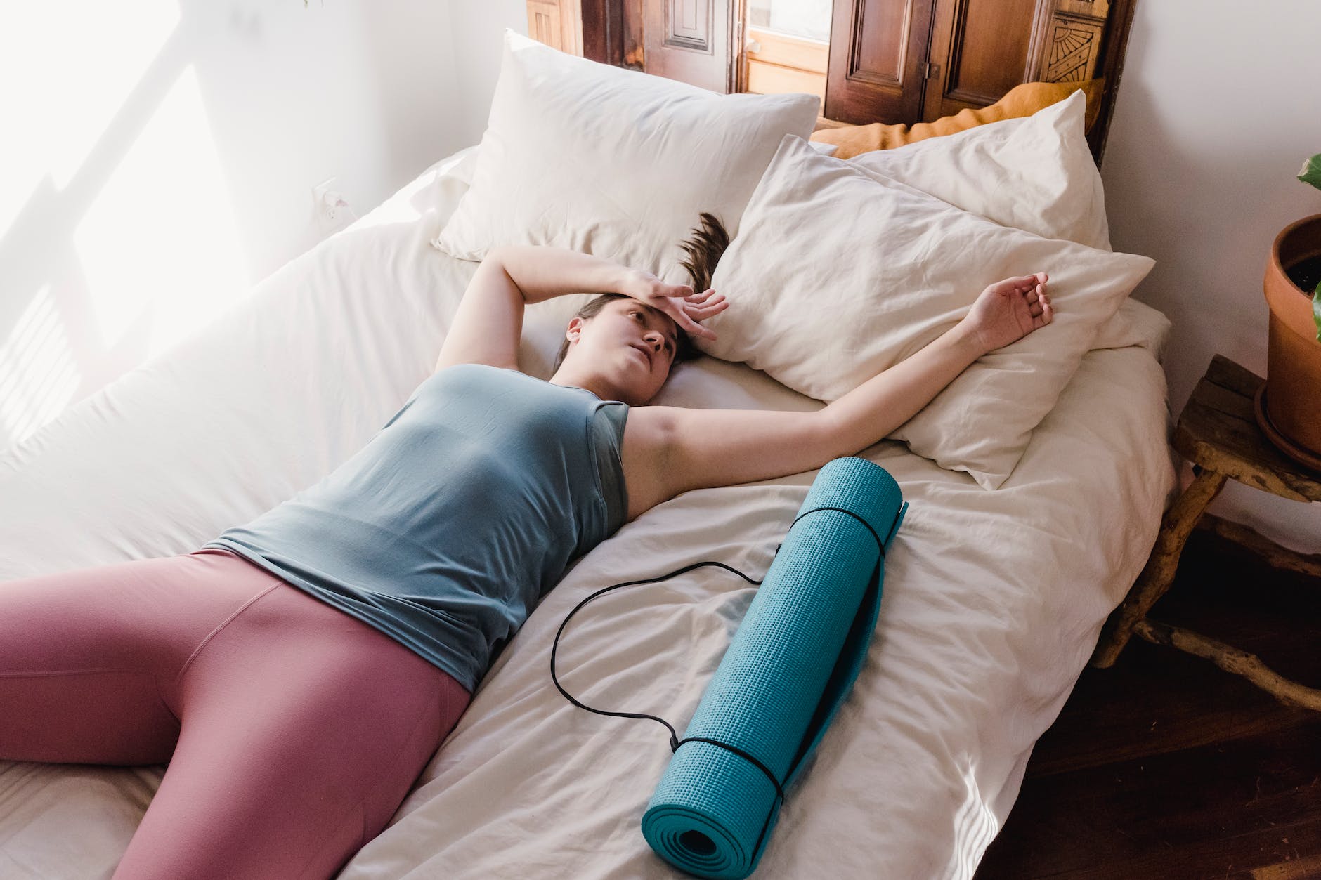 tired woman lying on bed after workout